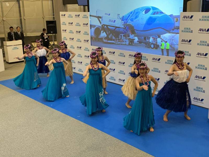 a group of women in blue dresses dancing