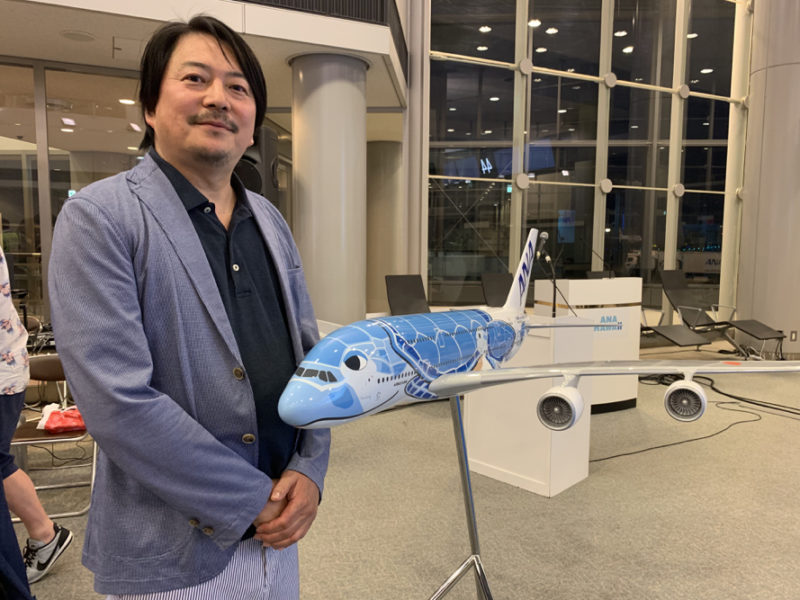 a man standing next to a model airplane