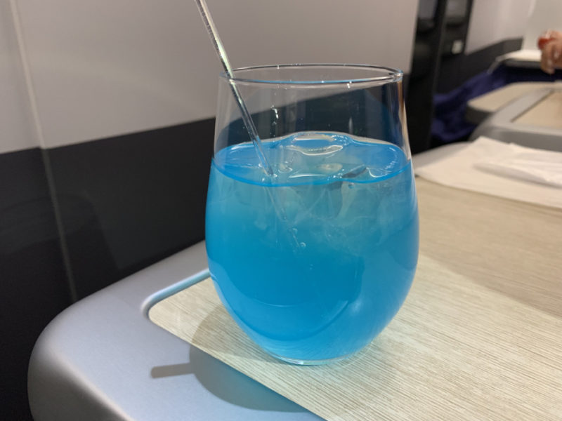 a glass with blue liquid and a straw