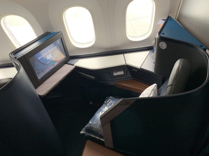 a seat in an airplane with a monitor and windows
