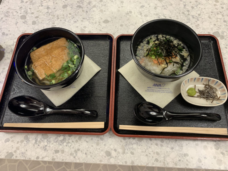 two bowls of soup and rice on trays