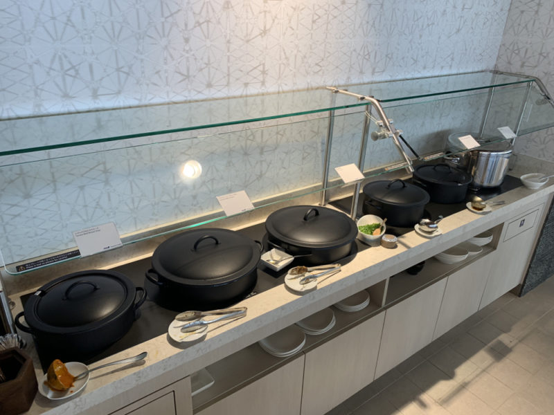 a row of black pots on a counter