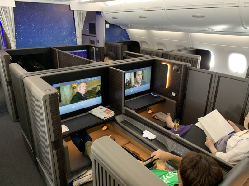 a group of people sitting in chairs in an airplane