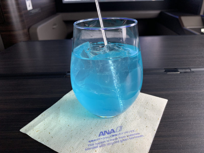 a glass with blue liquid and a straw