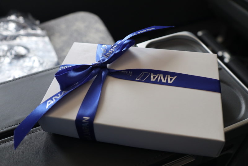 a white box with a blue ribbon on a black surface