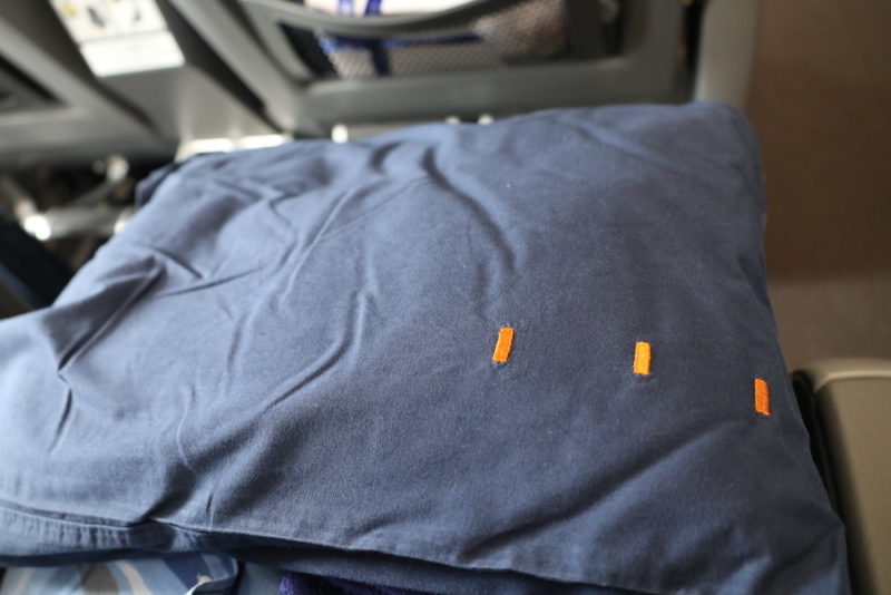 a blue shirt with orange stitching on it
