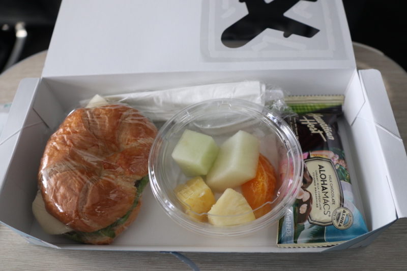 a sandwich and fruit in a plastic wrap