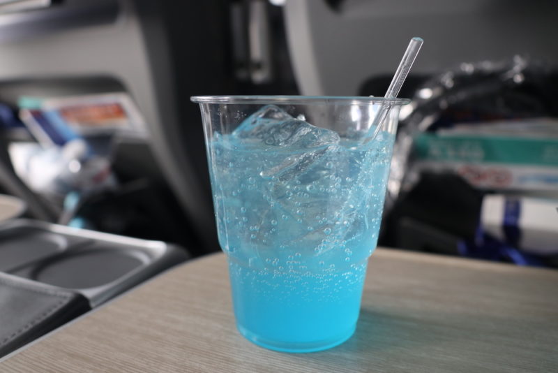 a clear plastic cup with blue liquid and ice