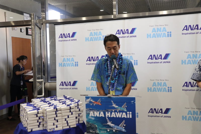 a man standing at a podium with a microphone and a bunch of white and blue objects