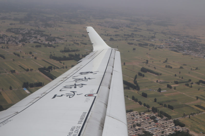 the wing of an airplane above a landscape