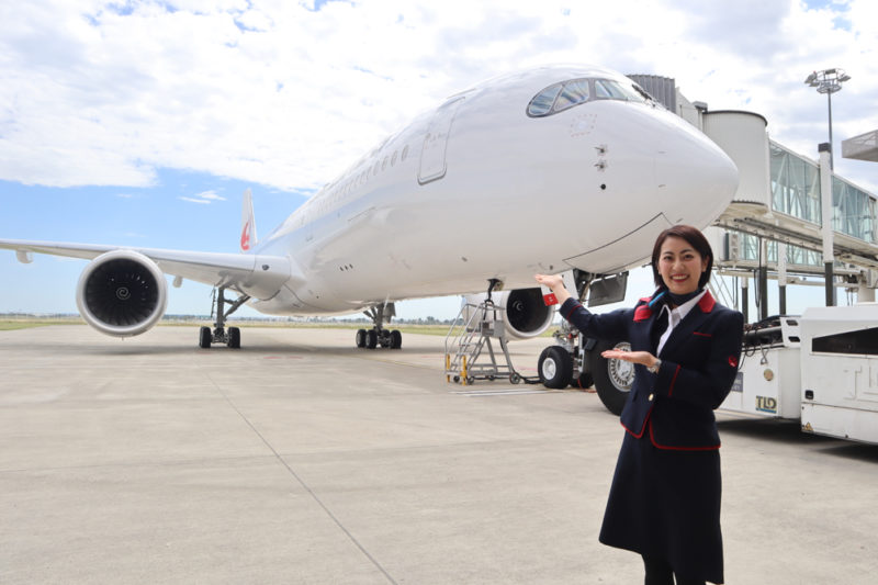 a woman standing in front of a large airplane