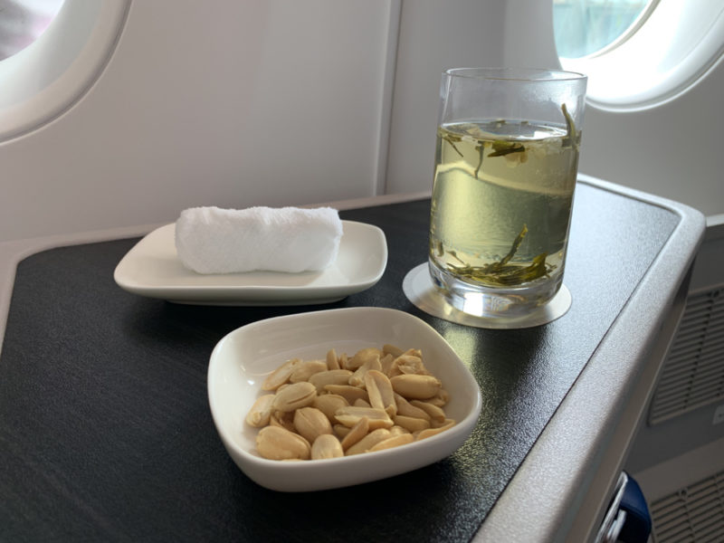 a plate of peanuts and a glass of water on a table