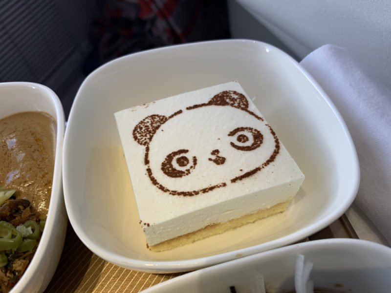 a square white cake with a panda face drawn on it