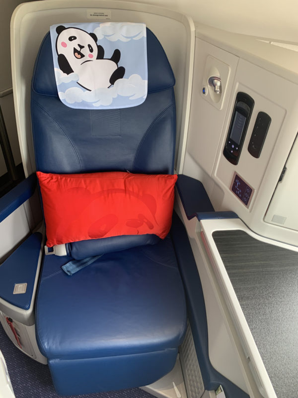a seat with a pillow and a panda on it