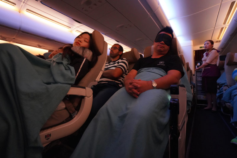 a group of people sleeping in an airplane