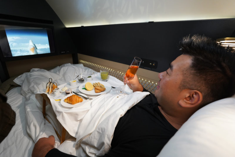 a man lying in bed with food on it