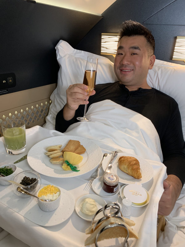 a man lying in bed with food on a tray