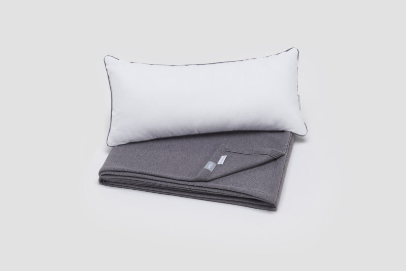 a white pillow on a grey blanket