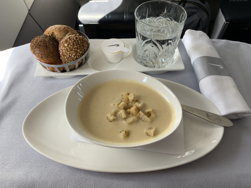 a plate of soup and bread on a tray