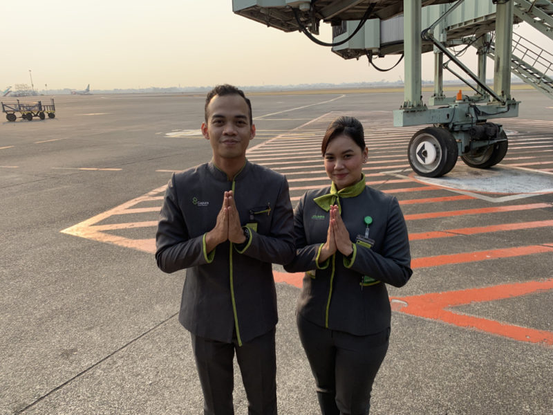 a man and woman standing in front of an airplane