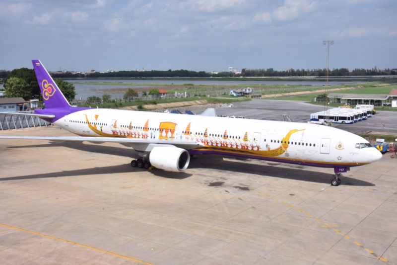 a large white airplane with a purple and white design on it