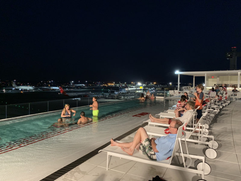 a group of people sitting in a pool at night