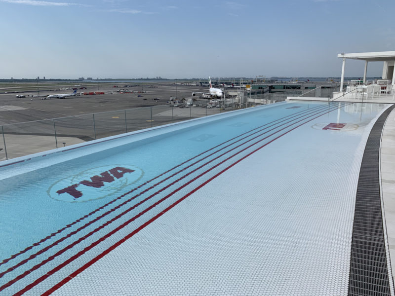 a swimming pool with planes in the background