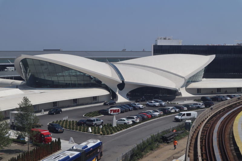 a white building with a curved roof and cars parked in front of it