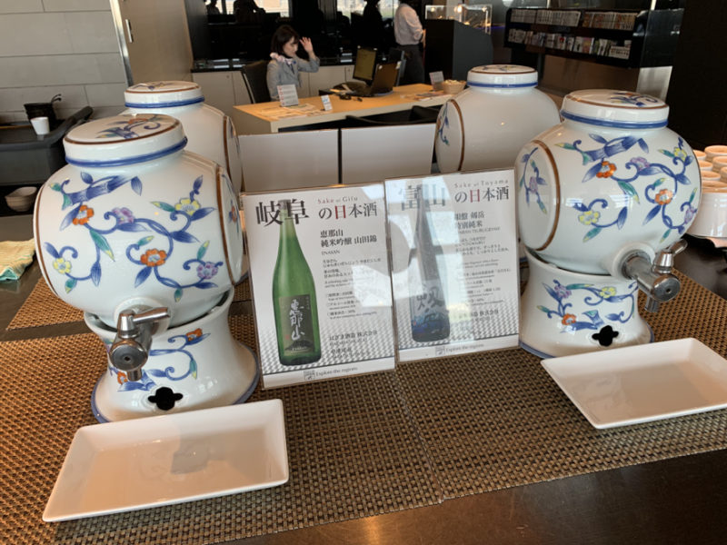 a group of white and blue porcelain urns with a drink dispenser