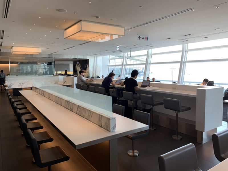 people sitting at a counter in a room with windows