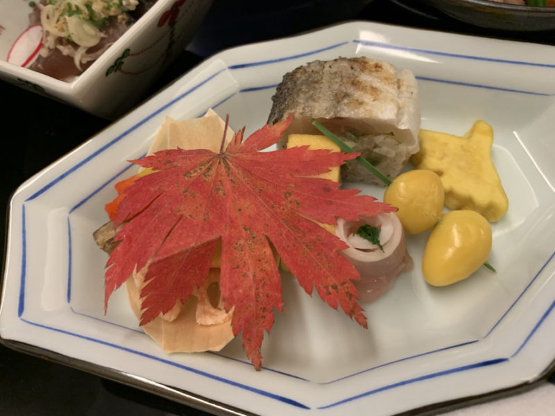 a plate of food with a red leaf