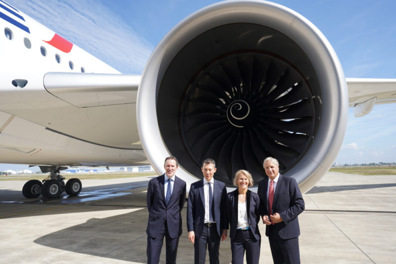 a group of people standing in front of a jet engine