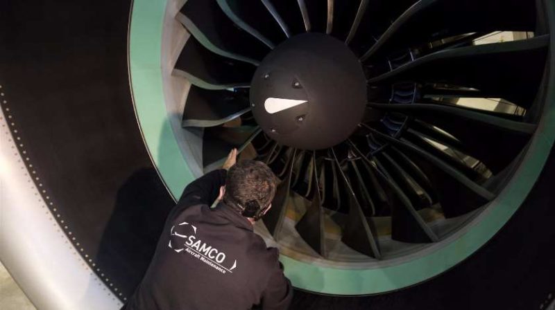 a man pointing at a jet engine