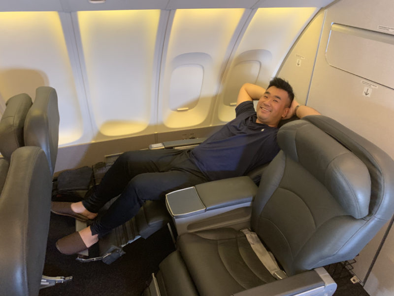 a man lying on a chair in an airplane