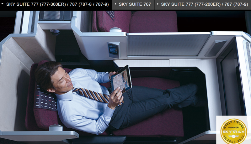 a man sitting in an airplane with a tablet