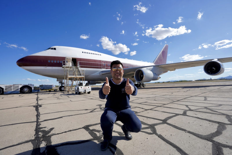 a man kneeling in front of an airplane