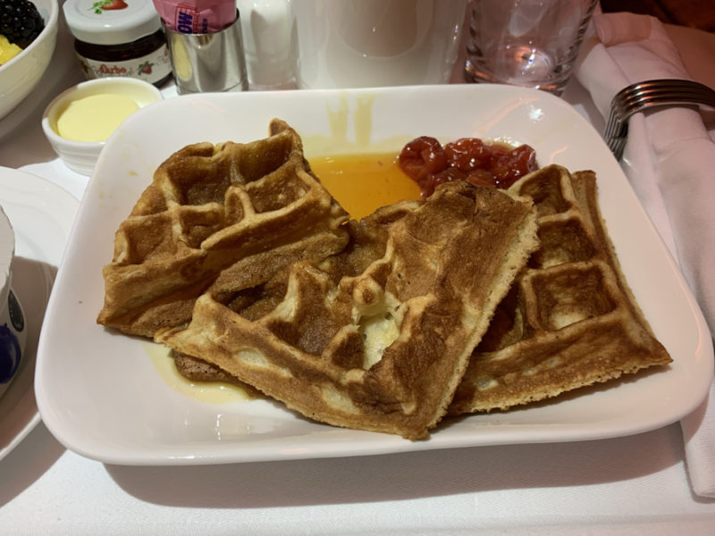 a plate of waffles and syrup