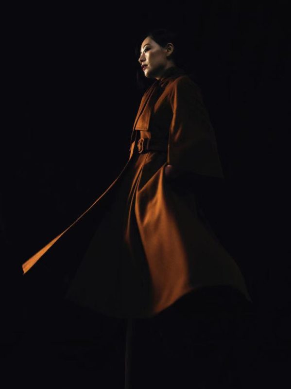 a woman in a long brown coat