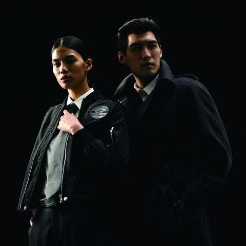 a man and woman in black coats