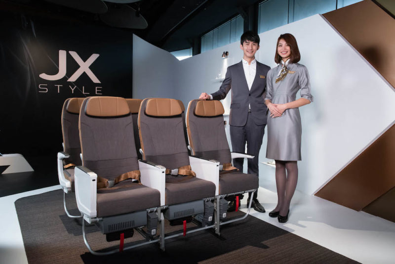 a man and woman standing next to a row of chairs