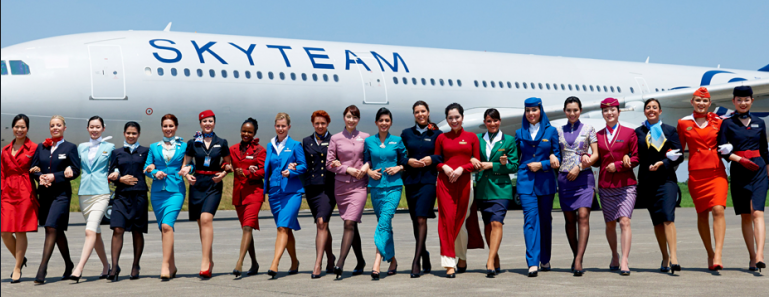 a group of women in uniform standing in front of a plane