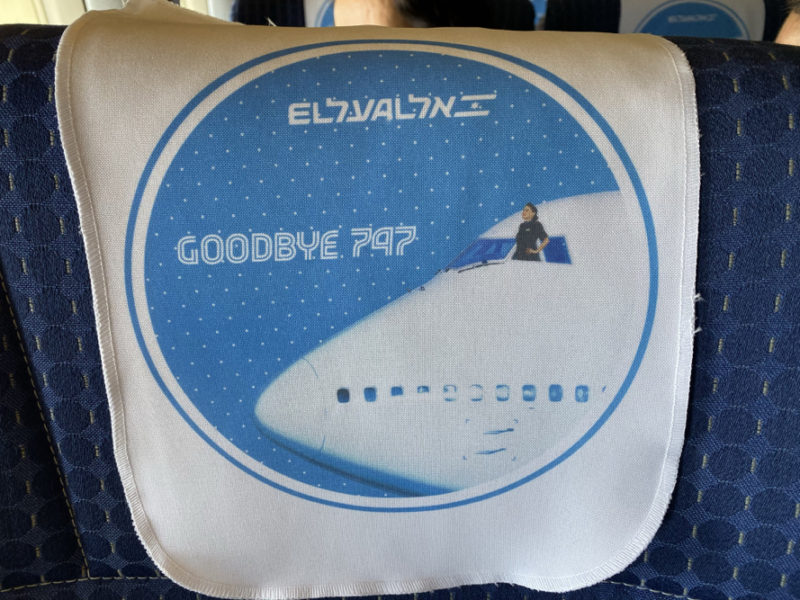 a white and blue towel with a picture of a plane and a woman sitting on a boat