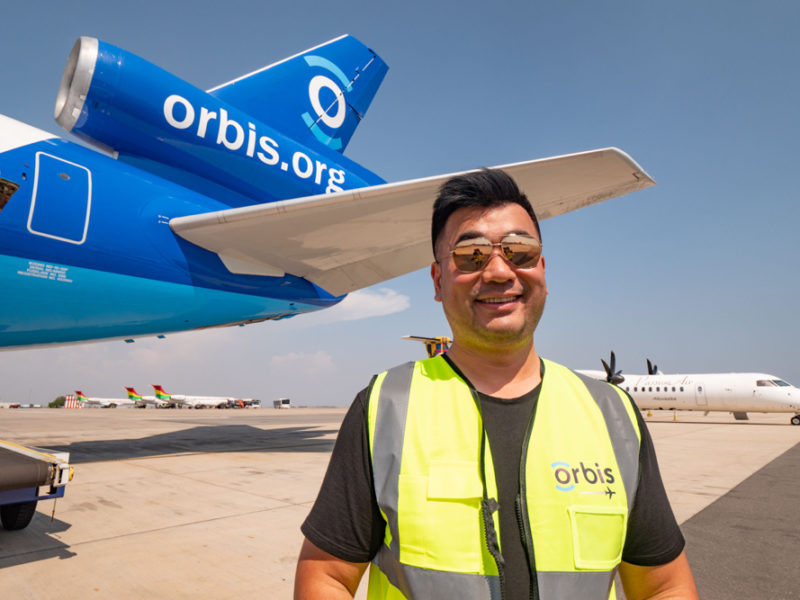 a man standing in front of a blue airplane