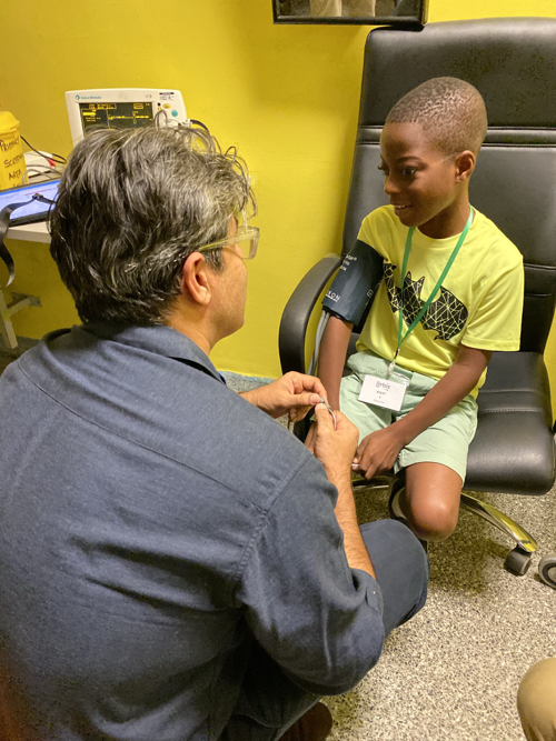 a man measuring a boy's blood pressure