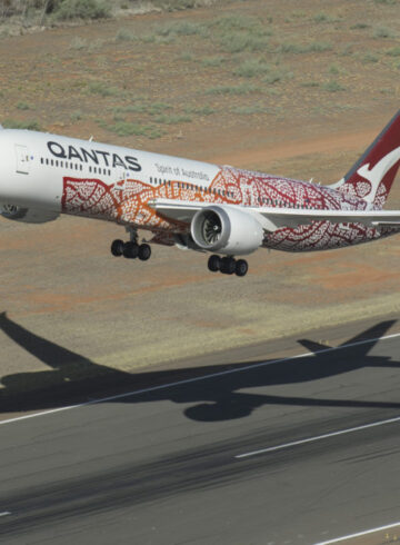 an airplane flying over a runway