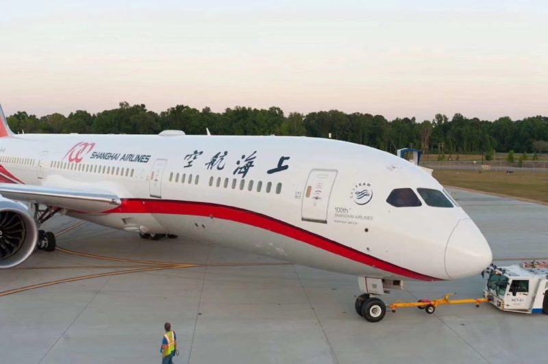 a large white airplane with red stripe on the side