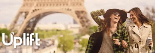 a woman in a sweater and a scarf in front of a tower