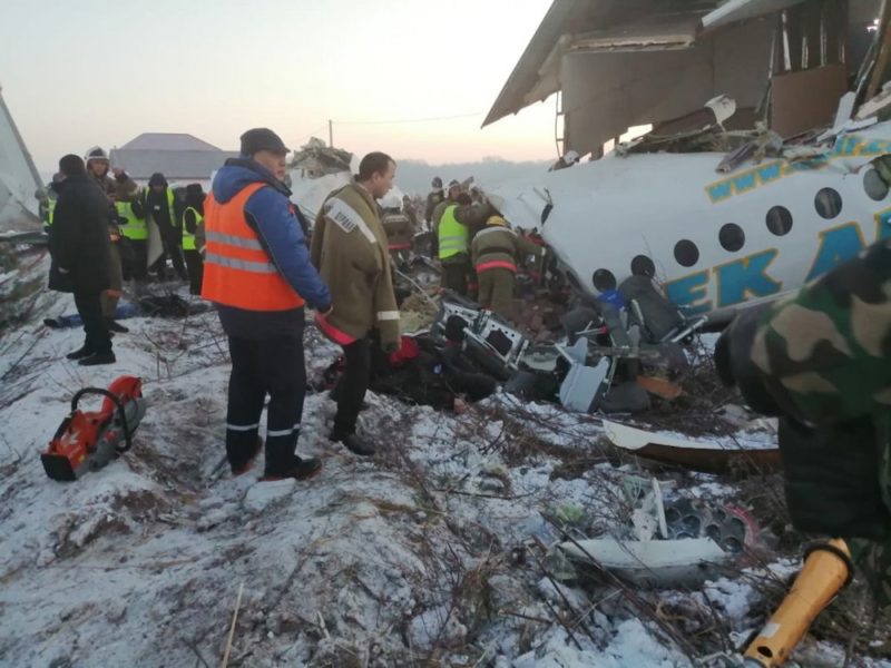 a group of people standing next to a crashed plane