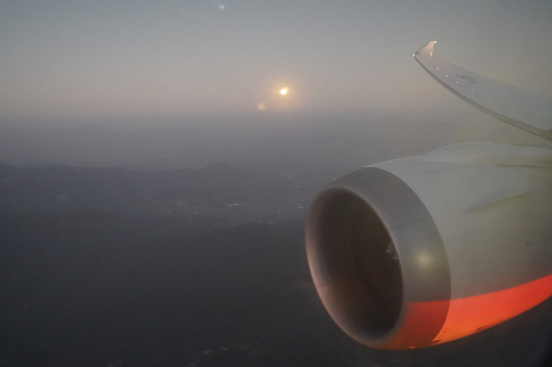 an airplane wing and the sun