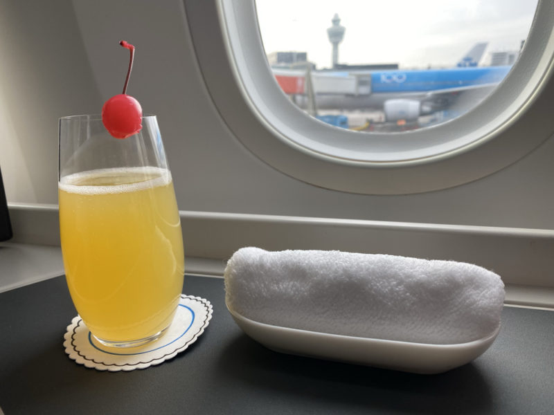 a glass of orange juice and a towel on a table